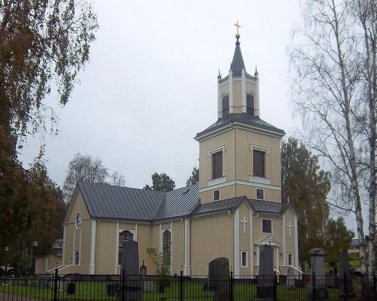 Älvsbyns kyrka en mulen höstdag, fotograferad mellan kyrkan och kyrkbyn.