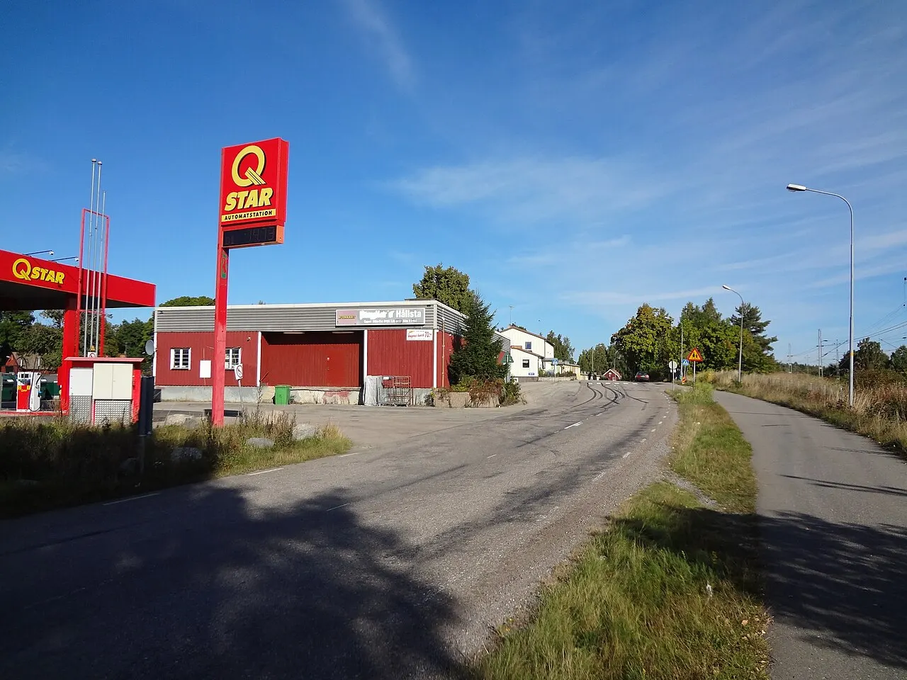 Hållsta, bensinstation, butik och pizzeria, järnvägen till höger i bild.