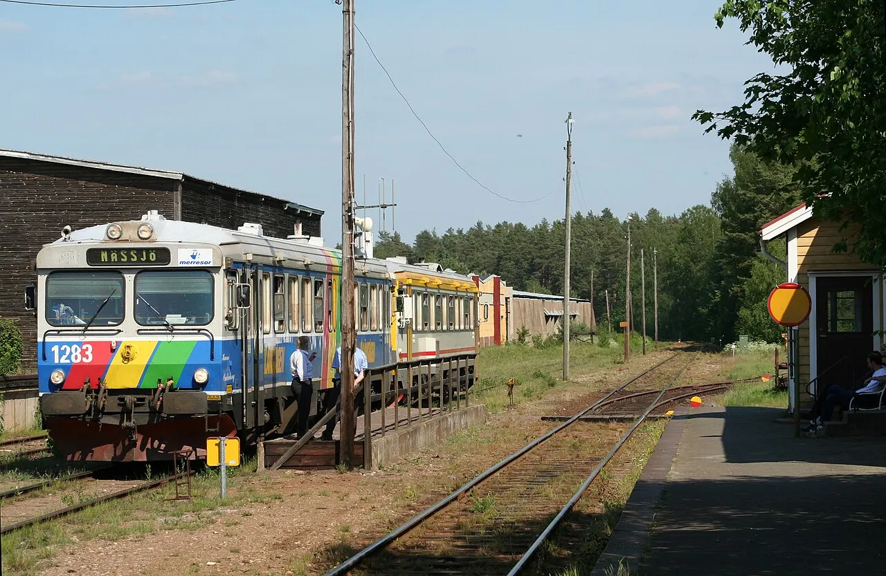 Två motorvagnar inväntar ett mötande tåg i det lilla samhället Hjältevad.