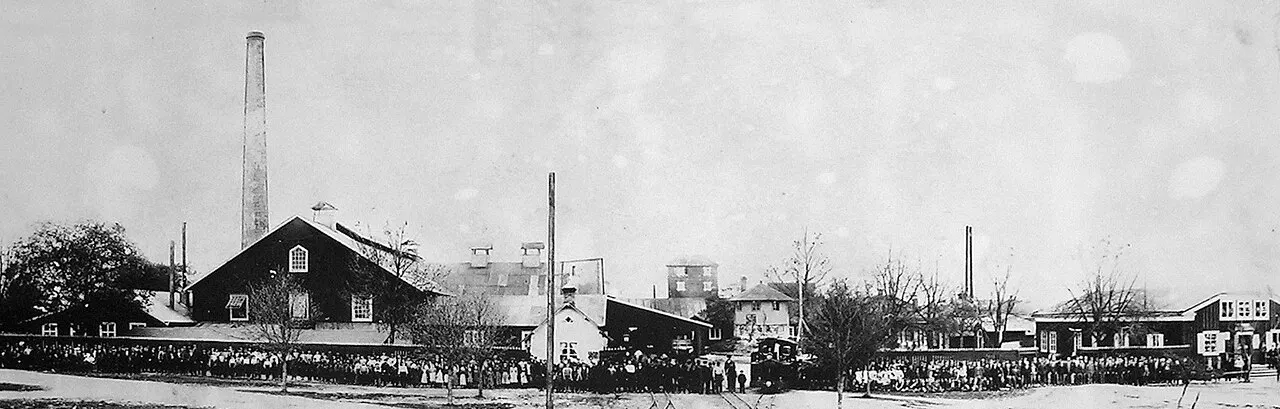 Personalen vid Kosta glasbruk i Sverige någon gång under 1890-talet. Ångloket är No 1 KOSTA. Den gamla hyttan, som brann ner 1901, ligger…