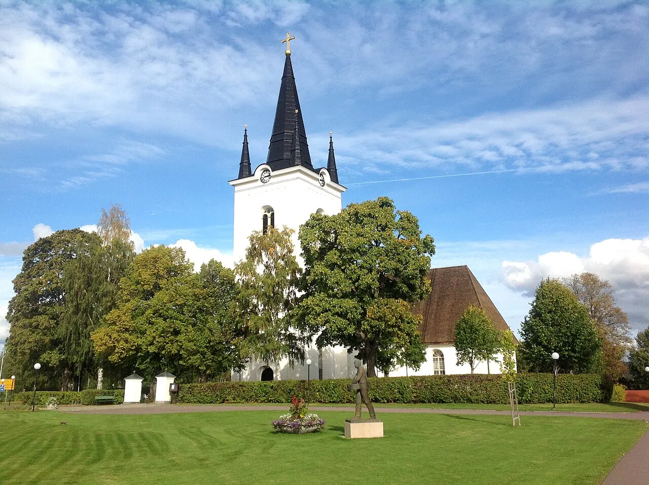 Svärdsjö kyrka i Västerås stift. På gräsmattan utanför kyrkan står en skulptur som heter “Såningsmannen”. Skulpturen är från 1969 av Arvid…